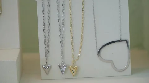 Showcasing handmade heart-shaped jewelry in a bright boutique setting during a Vídeo Stock 318202553
