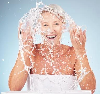 Shower, face and old woman with smile and water splash, clean skin and antiaging Stock Photos