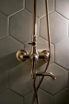 Shower fixture mounted on hexagonal tiled wall Stock Photos
