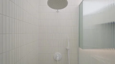 Shower fixture unit features water mixer tap with overhead rain head panel. Stock Footage 335540944