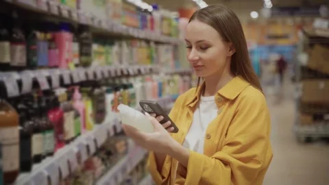 Shower gel scanning in store by a customer while comparing options and checking Stock Footage 305413251
