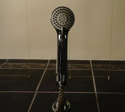 Shower handle bottom view chrome color. On the background is a black shower t Stock Photos
