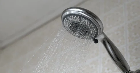 Shower head close-up with water flowing in slow-motion, bath time concept Stock Footage 250191360