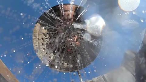 Shower head spraying refreshing water against a clear blue sky, creating a Stock Footage 342763022