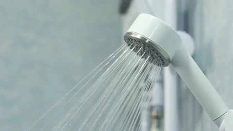 Shower head with water drops splashing out and running from faucet in bathroo Stock Footage 233155939