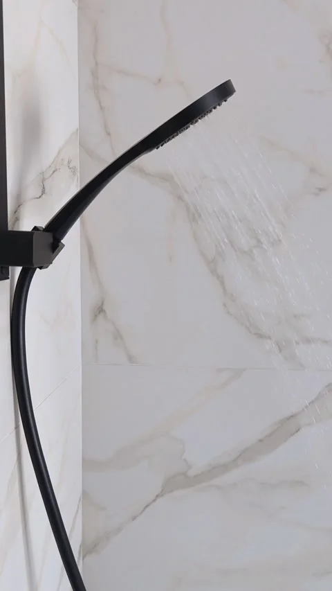 Shower head with water drops splashing out and running from faucet in bathroom. Stock Footage 316688448