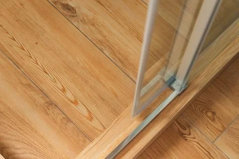 Shower stall threshold. The floor is made of wood-look tile and the shower is Stock Photos