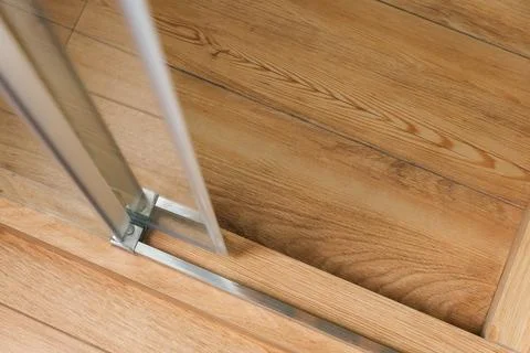 Shower stall threshold. The floor is made of wood-look tile and the shower is Stock Photos