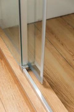 Shower stall threshold. The floor is made of wood-look tile and the shower is Stock Photos