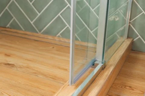 Shower stall threshold. The floor is made of wood-look tile and the shower is Stock-Fotos