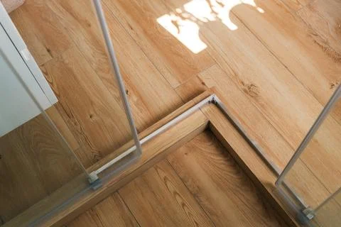 Shower stall threshold. The floor is made of wood-look tile and the shower .. Stock Photos