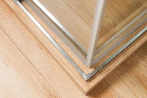 Shower stall threshold. The floor is made of wood-look tile and the shower is Stock Photos