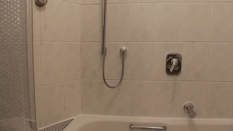 Shower turning on, water flowing, Camera moves up Stock Footage