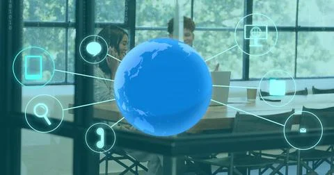 Showing blue 3D globe over table in office, linking icons to laptop phone team Stock Photos