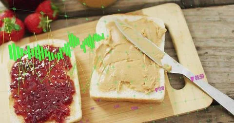 Showing bread slices sitting on cutting board bearing jam and peanut spread, 写真素材
