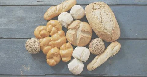 Showing breads resting on weathered blue-gray plank, featuring crusty loaf, Stock Photos