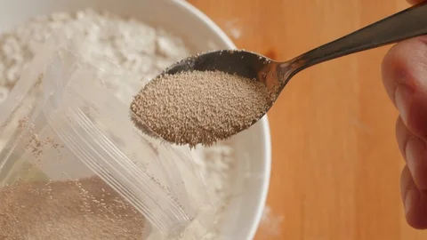 Showing to camera spoon teaspoon of dry instant yeast close macro Stock Footage 127714722