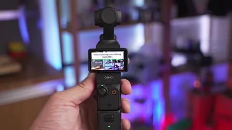 Showing the DJI Osmo Pocket 3 portable mini HD camera, 4K shot Video stock 299725470