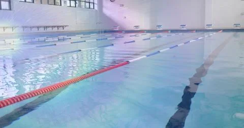 Showing empty pool reflecting sun, lined with lane ropes and ladder in aquatic Stock Photos