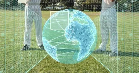 Showing hologram globe hovering between two men in white pants, shoes on grass, 스톡 사진