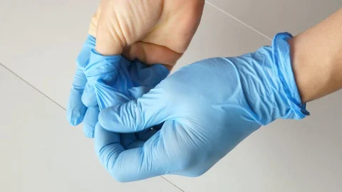 Showing how to remove blue protective gloves correctly Stock-Footage 129390458