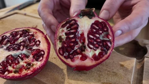 Showing the Inside of a Cut Pomegranate Stock-Footage 348108393