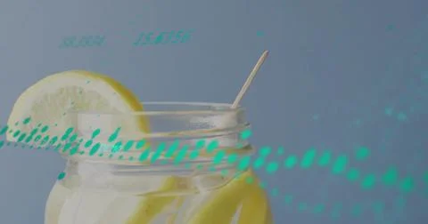 Showing mason jar holding lemon slices, wedge, ice, stick on table, dew and teal Stock Photos