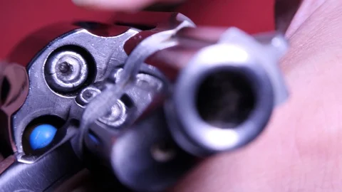Showing mixed types of bullets in revolver's chambers frontal view close up Stock Footage 114417322