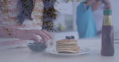 Showing pancake stack with blueberries on kitchen counter, adult reaching int Stock Photos