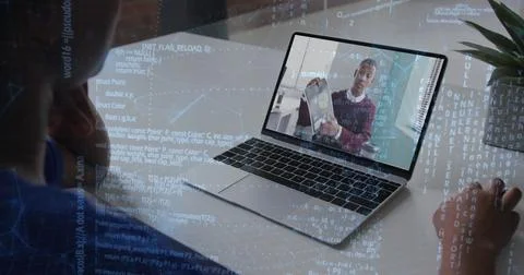 Showing remote engineer holding laptop as coworker typing code at modern office Stock Photos