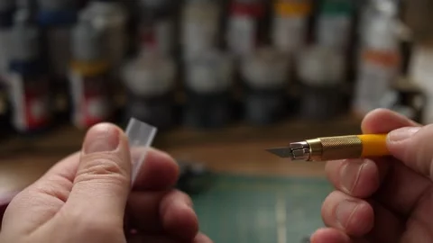 Showing sharp modeling hobby knife, minis for rpg game, cleaning moldlines Stock Footage 260825290
