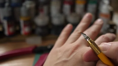 Showing sharp modeling hobby knife, minis for rpg game, cleaning moldlines Stock Footage 260825389