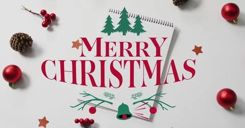 Showing spiral-bound notepad MERRY CHRISTMAS text on white table with red Stock Photos