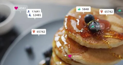 Showing stack of three pancakes dripping syrup at cafe tabletop with blueberries Stock Photos