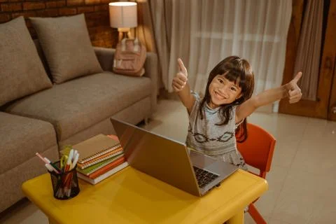 Showing thumb up while doing homework Fotos Stock