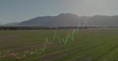 Showing translucent financial chart overlay over farmland, with wind turbines Stock Photos