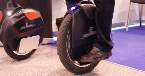 Showing of two modern electric monowheels indoor at exhibition Stock Footage 276362724