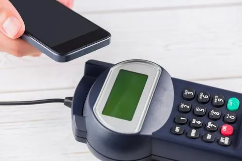 Showing vector terminal, green screen and keypad on white table, hand tapping Stock Photos