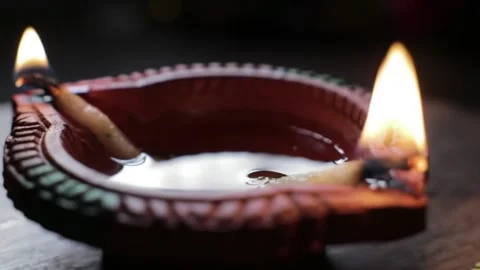 Shows a plate containing a clay diya lamp filled with oil and a burning cotton w Stock Footage 318554308