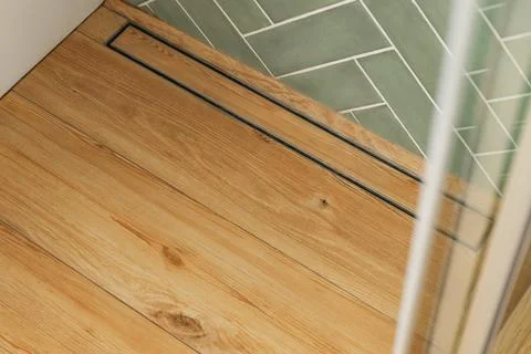 Shows a shower stall floor with a linear drain. The floor is made of wood-loo Stock Photos