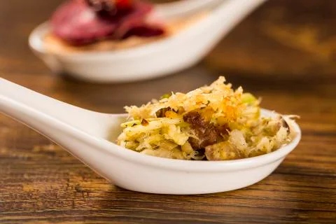 Shredded cod with scrambled eggs, banana puree and crispy potato in a spoon.. Stock Photos