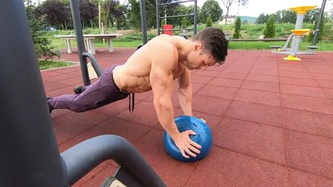Shredded guy doing push ups with water ball Video stock 137801697