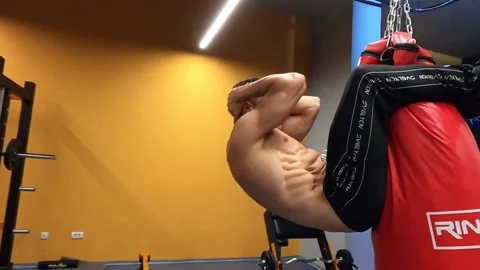 Shredded guy workout his six pack on the boxing bag Video stock 138855171