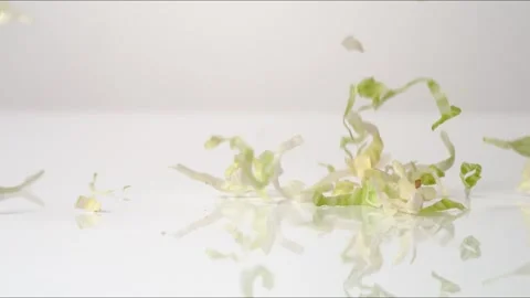 Shredded Iceburg Lettuce Bouncing Slow Motion White Tabletop Closeup Macro Food Stock Footage 335006896