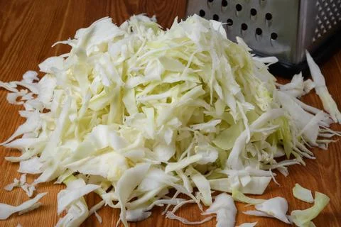 Shredded white cabbage on the table next to the grater Stock Photos