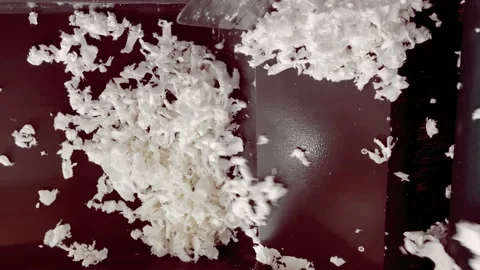 Shredded white colored textile material being transported for recycling. Slow Stock Footage 233933499
