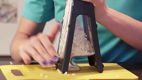 Shredding cheese on grater Stock Footage 74097901