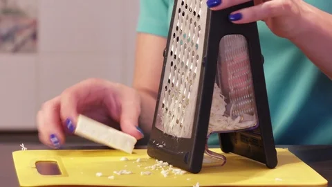 Shredding cheese on grater Stock Footage 74332739