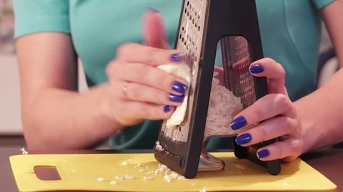Shredding cheese on grater Stock Footage 74727020