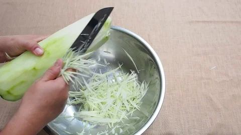 Shredding green papaya traditionally by knife, slicing step Stock Footage